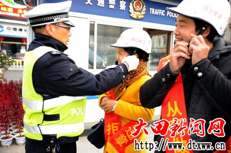 圖為：民警正在為群眾戴上安全頭盔.jpg